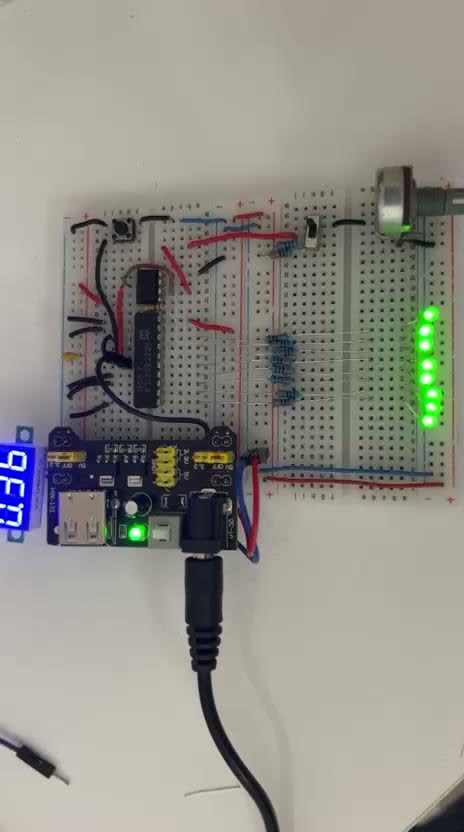 Breadboarded 8-bit ADC circuit with an LED bar graph, 7-segment display, and potentiometer input